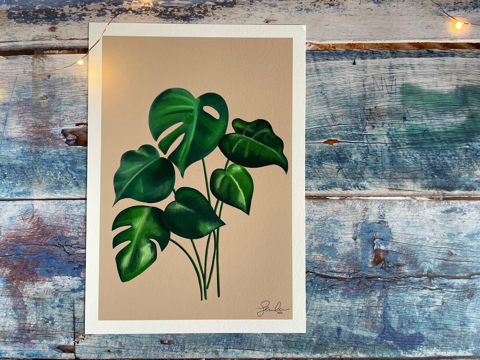 A photo of an A4 and A5 giclee print of a digitally illustrated monstera