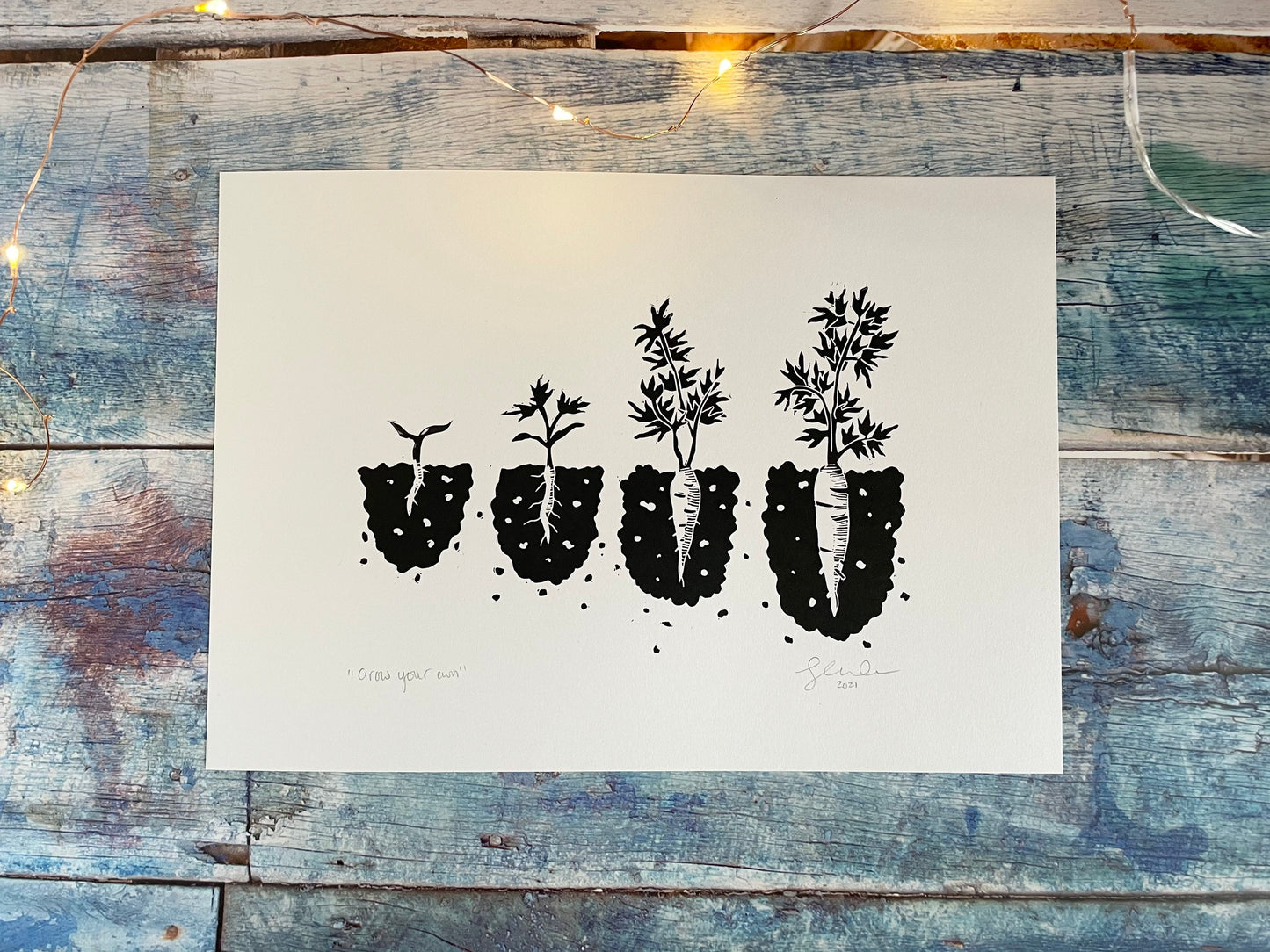 A lino print showing the different stages of a carrot growing from seedling to ready to pick in black