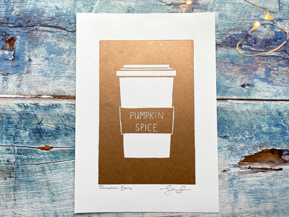 A simplistic lino print of a pumpkin spice latte in a takeout cup in copper