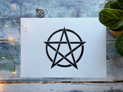 A simple black lino print of a pentagram in a circle