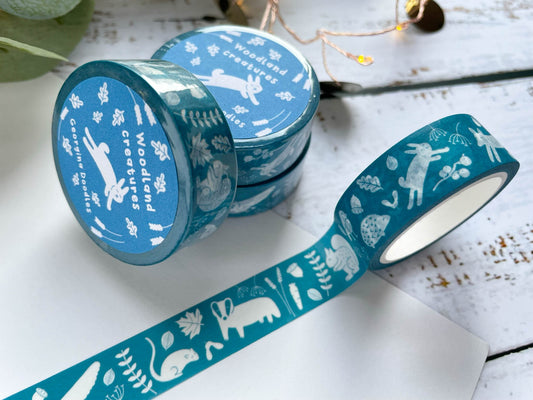 A blue/teal coloured washi tape with white woodland illustrated animals on