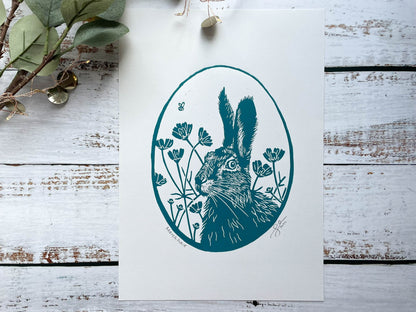 An oval lino print of a hare surrounded by flowers printed on A4 paper