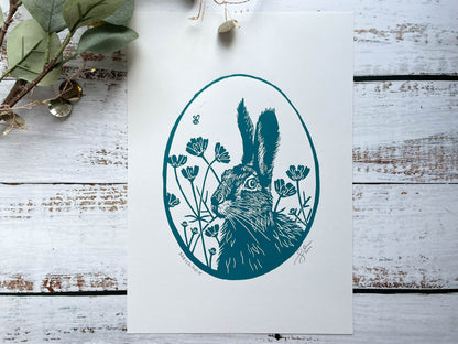 An oval lino print of a hare surrounded by flowers printed on A4 paper