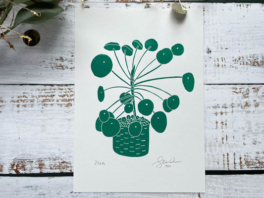 A green A5 lino print of a pilea plant