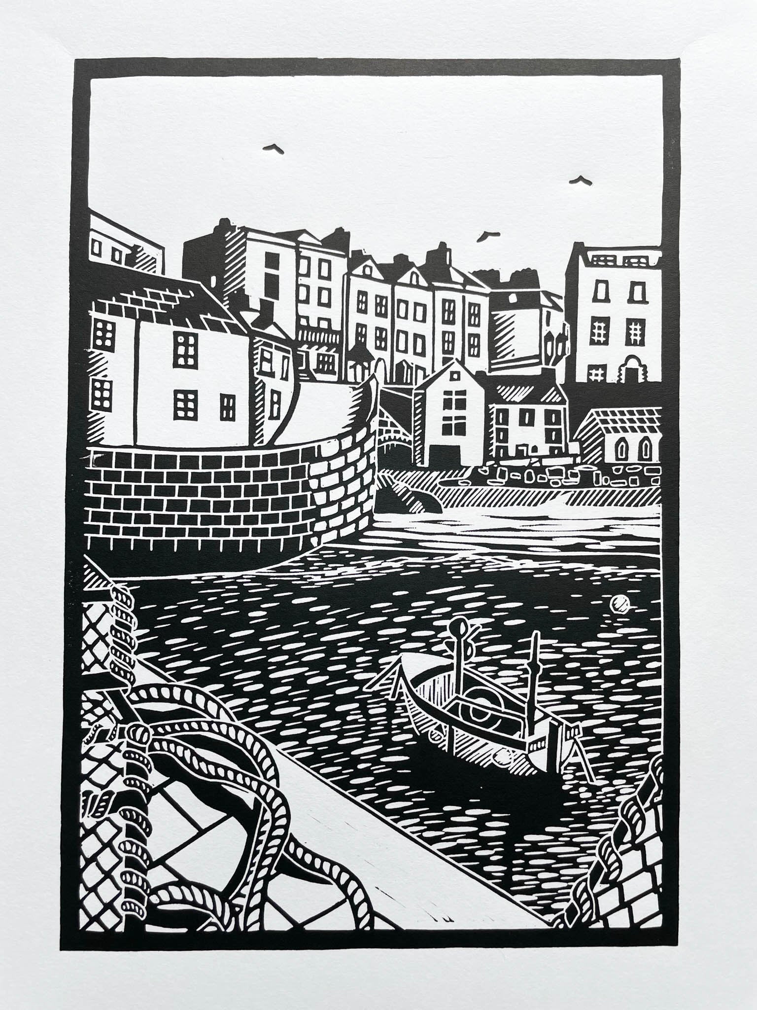 An A4 lino print of the iconic Tenby harbour in black