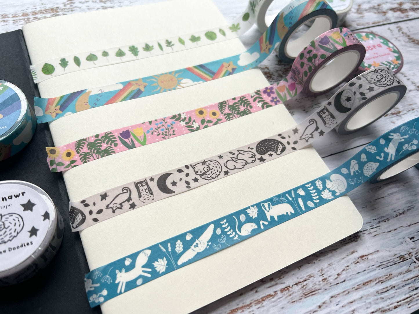 Five different rolls of washi tape across a notebook