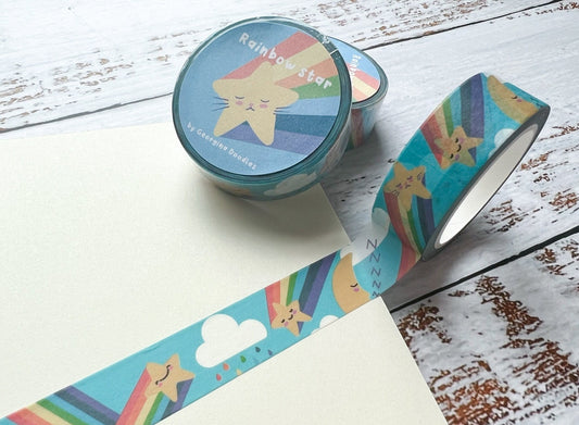 A close up of washi tape with cute rainbows, moons, stars and clouds on a blue background.