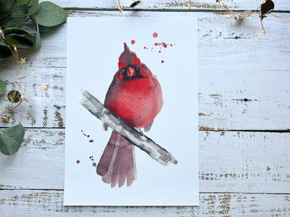 A print of a watercolour painting of a cardinal looking straight at you