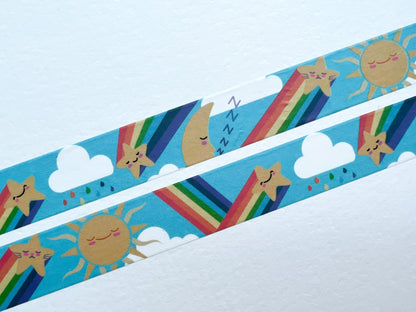A close up of washi tape with cute rainbows, moons, stars and clouds on a blue background.